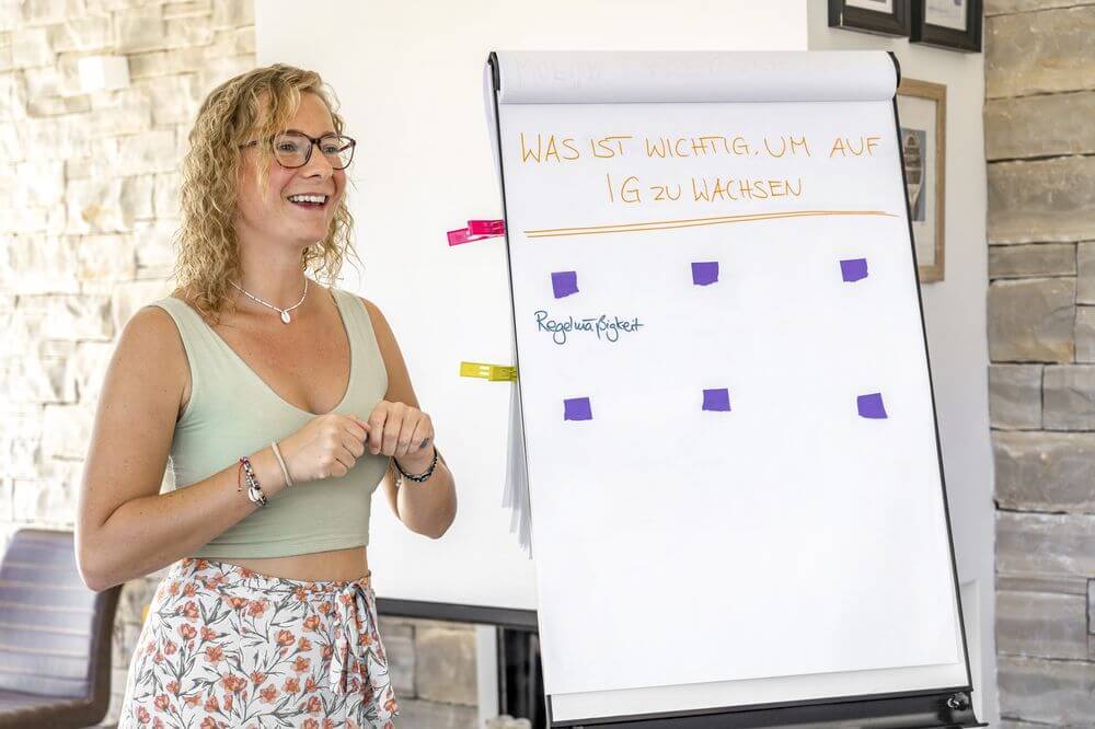 Eine Teilnehmer:in spricht vor der Gruppe &uuml;ber ihr Business