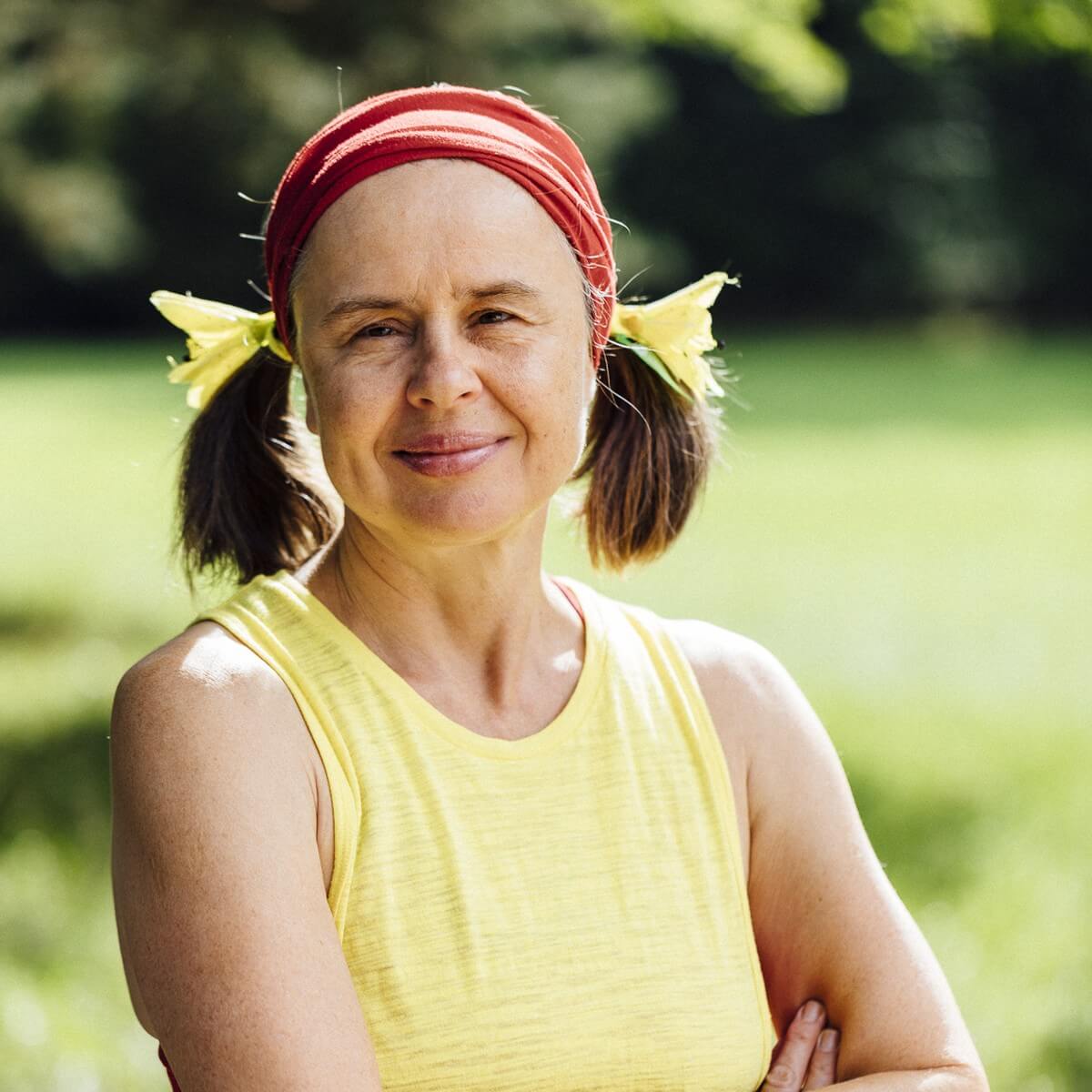 Karin Lochner mit rotem Stirnband und gelbem Top im Park