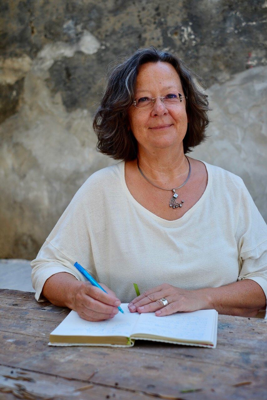 Ingrid Werner zeichnet mit einem Buntstift in ein Notizbuch
